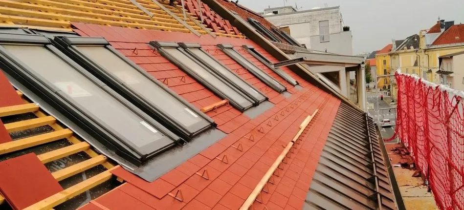 Zwei Dachflächenfenster in einem roten Ziegeldach während der Bauarbeiten