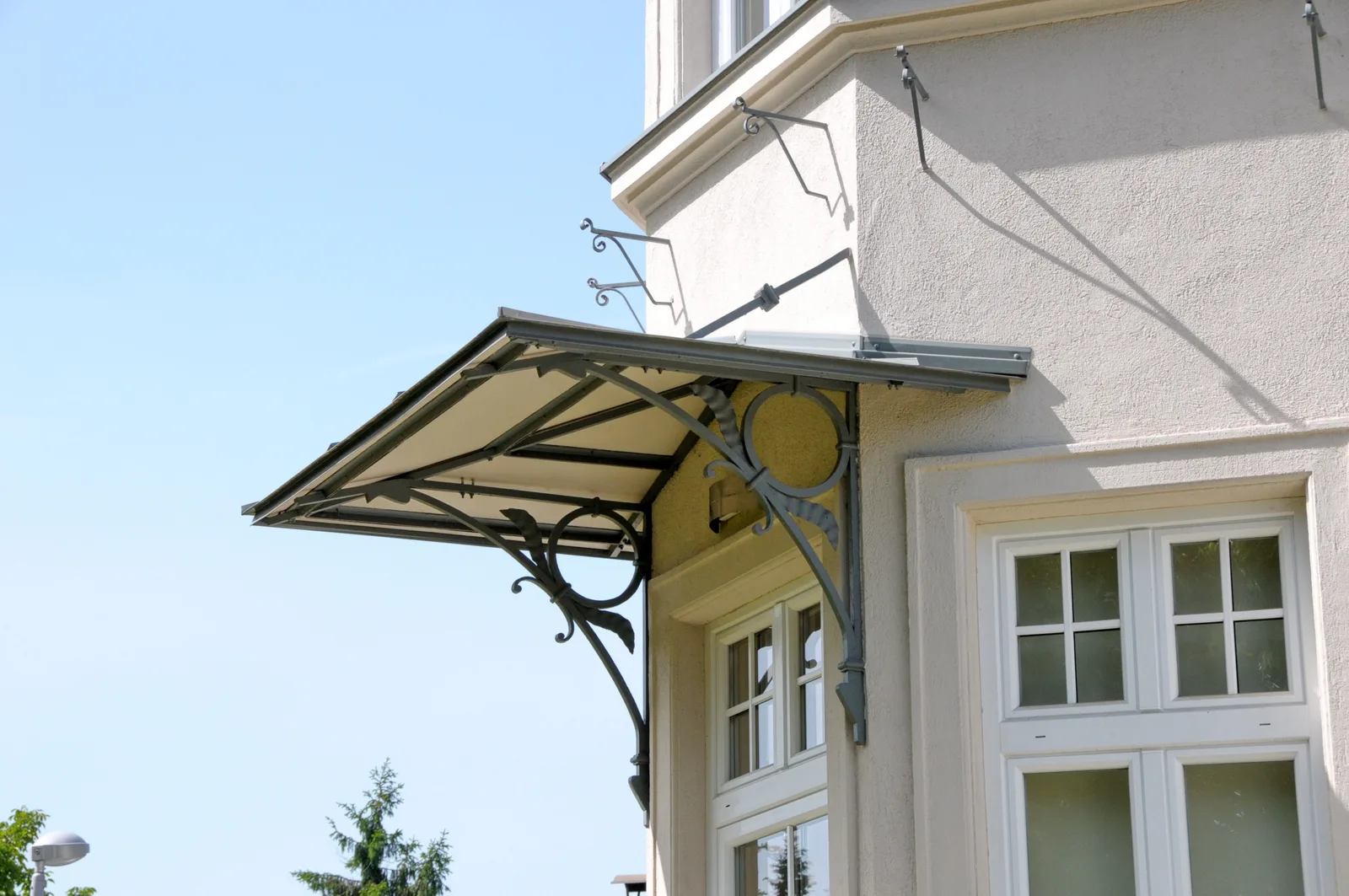Schmiedeeisernes Vordach mit neuer Blechabdeckung über einem Fenster